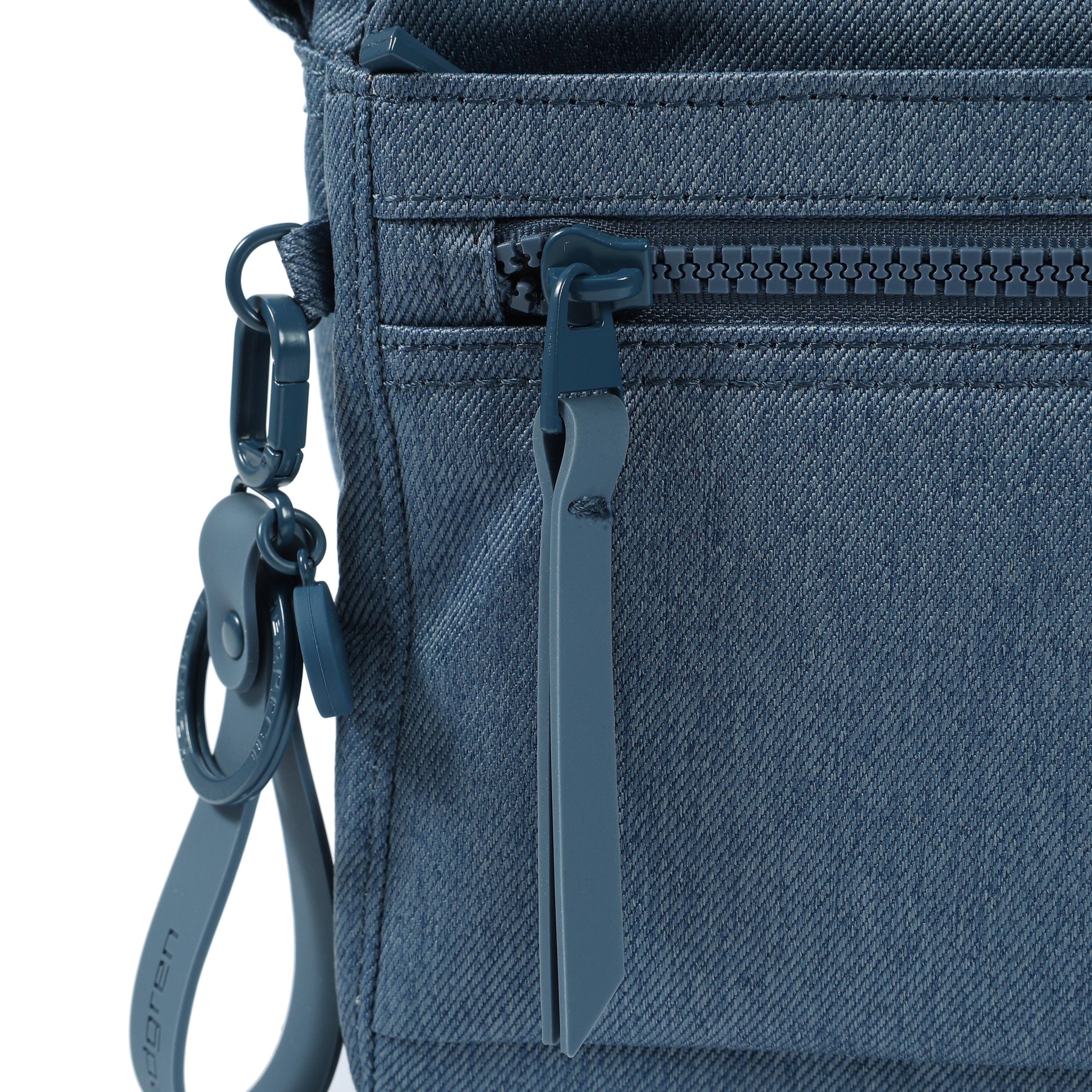 Close up of zipper on Eye RFID Shoulder Bag #color_vintage indigo jean
