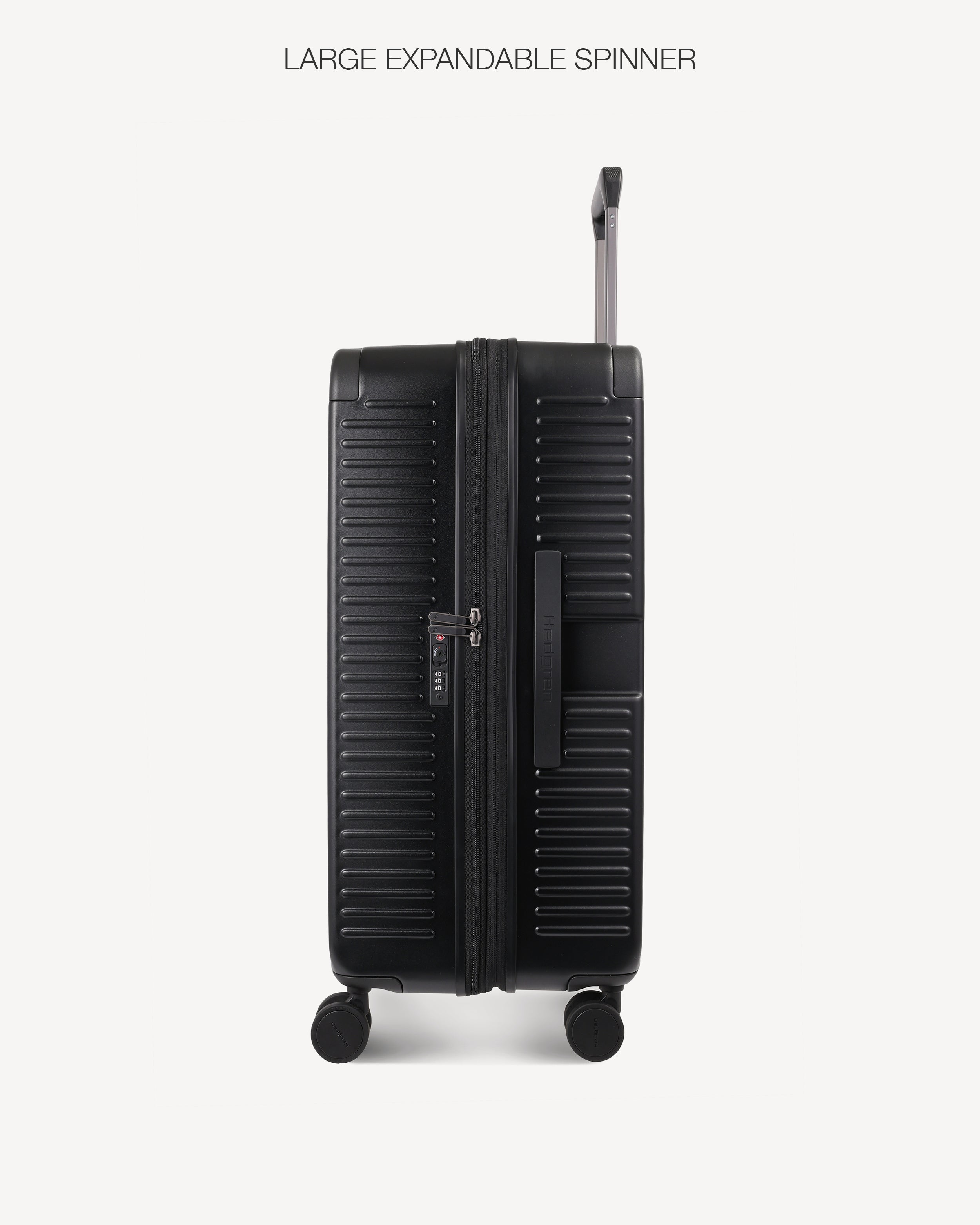A black hard-shell spinner suitcase with a ribbed exterior and telescoping handle extended, shown against a light gray background with the text 'LARGE EXPANDABLE SPINNER' above it.