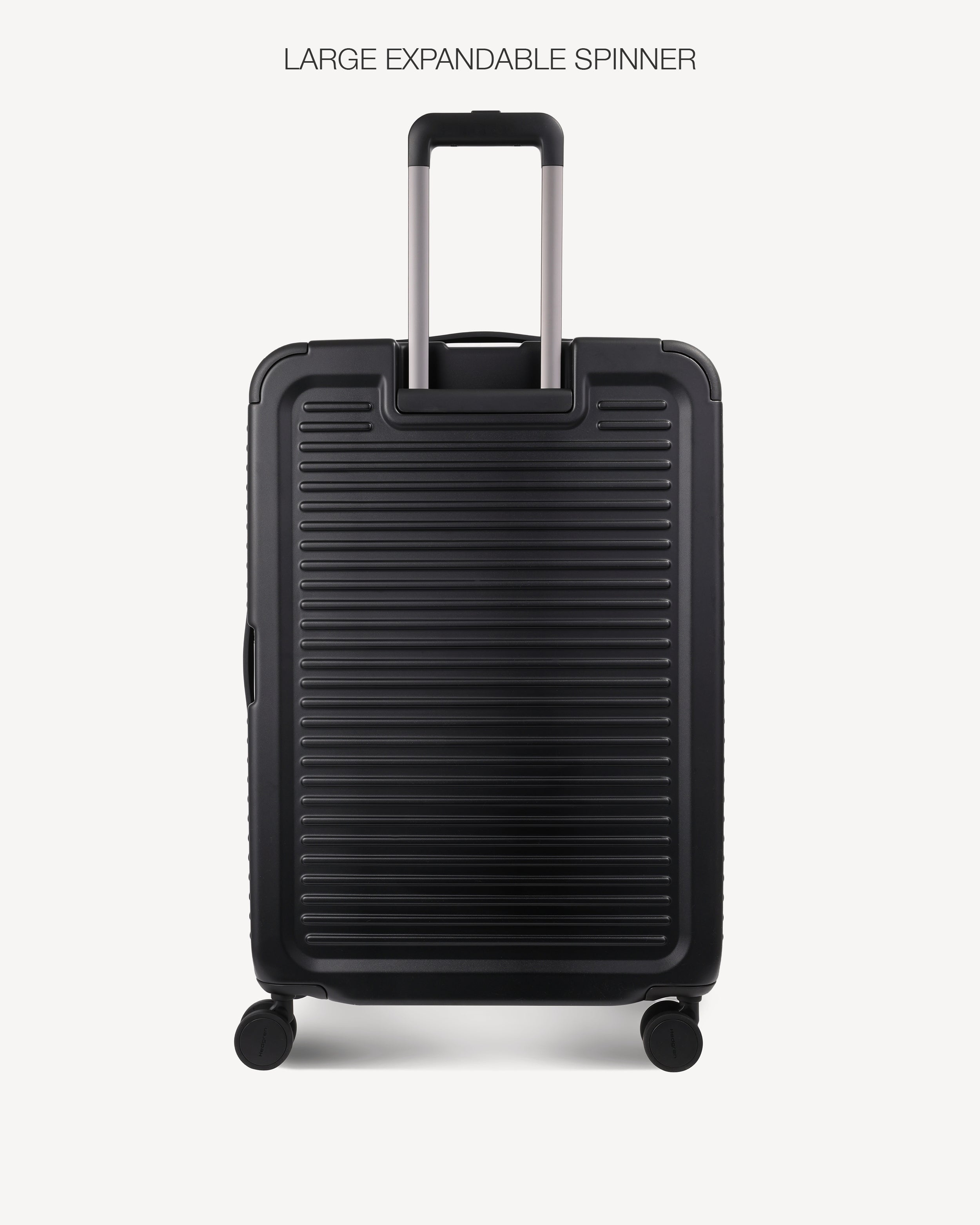 A black hardshell spinner suitcase with a ribbed front panel and telescoping handle, shown on a light gray background with the text 'LARGE EXPANDABLE SPINNER' above it.