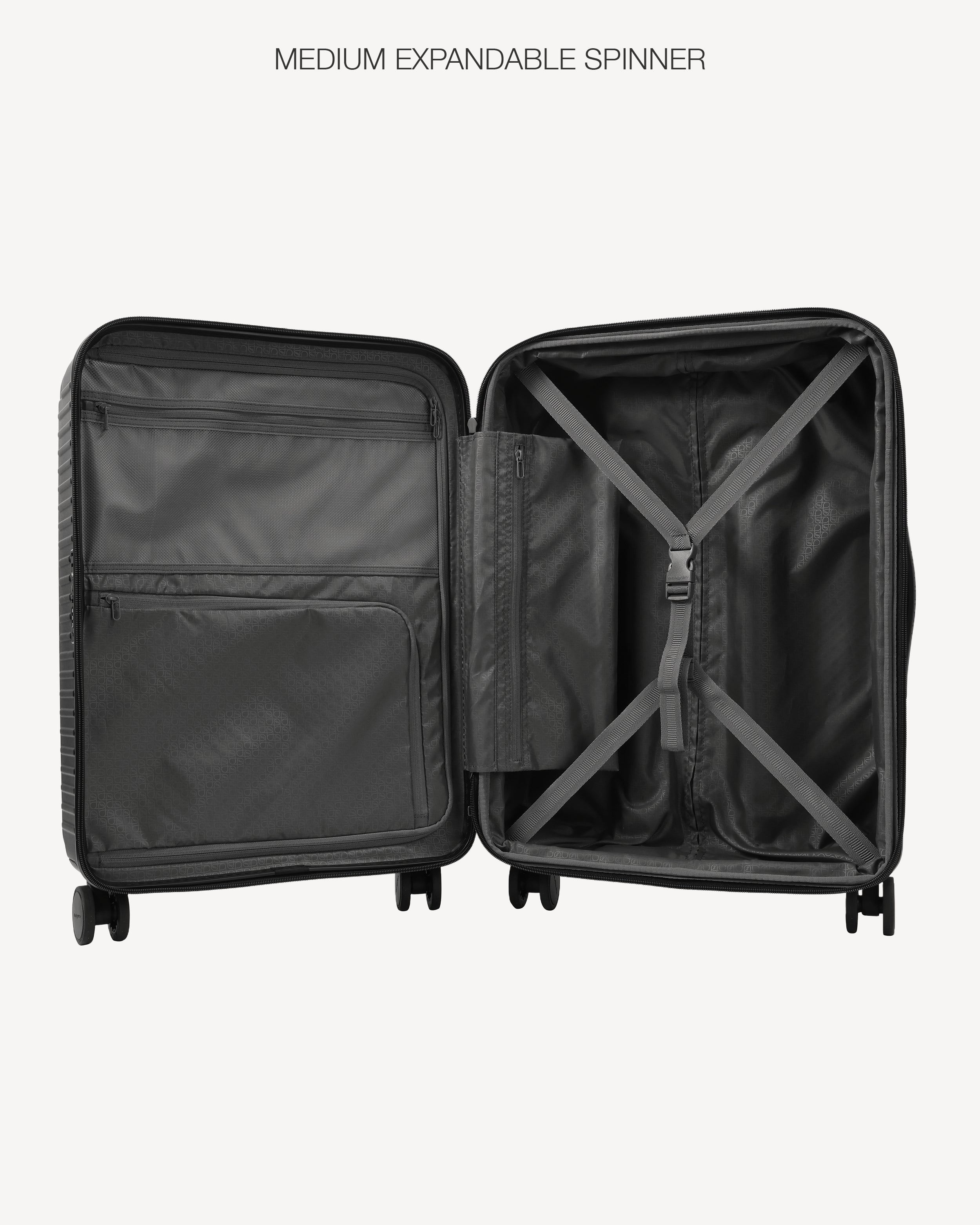 An open black hard-shell spinner suitcase shown from the inside, displaying the spacious interior, zippered compartments, and X-straps on a light gray background with the text 'MEDIUM EXPANDABLE SPINNER' at the top.