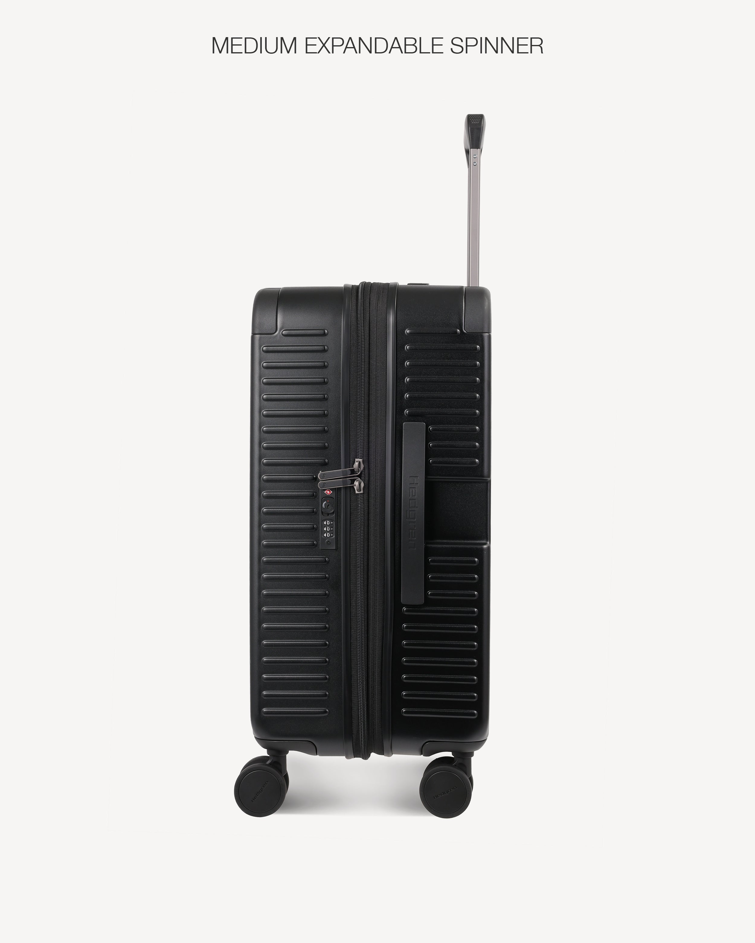 A black hard-shell spinner suitcase with a telescoping handle extended, shown from the back against a light gray background. The text 'MEDIUM EXPANDABLE SPINNER' is printed at the top.