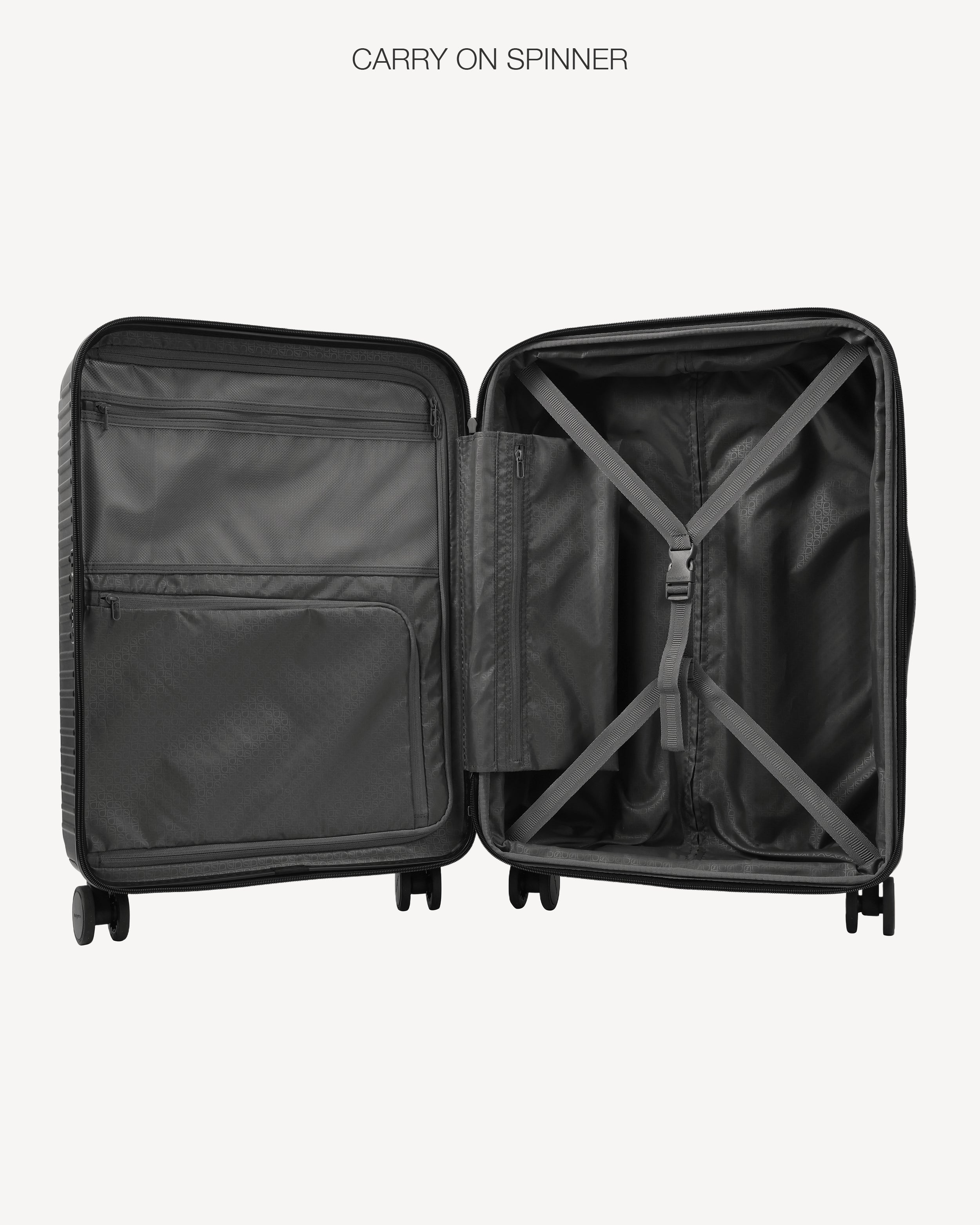 An open black spinner suitcase shown from the inside, displaying the spacious interior, zippered compartments, and X-strapping system, set against a light gray background with the text 'CARRY ON SPINNER' at the top.
