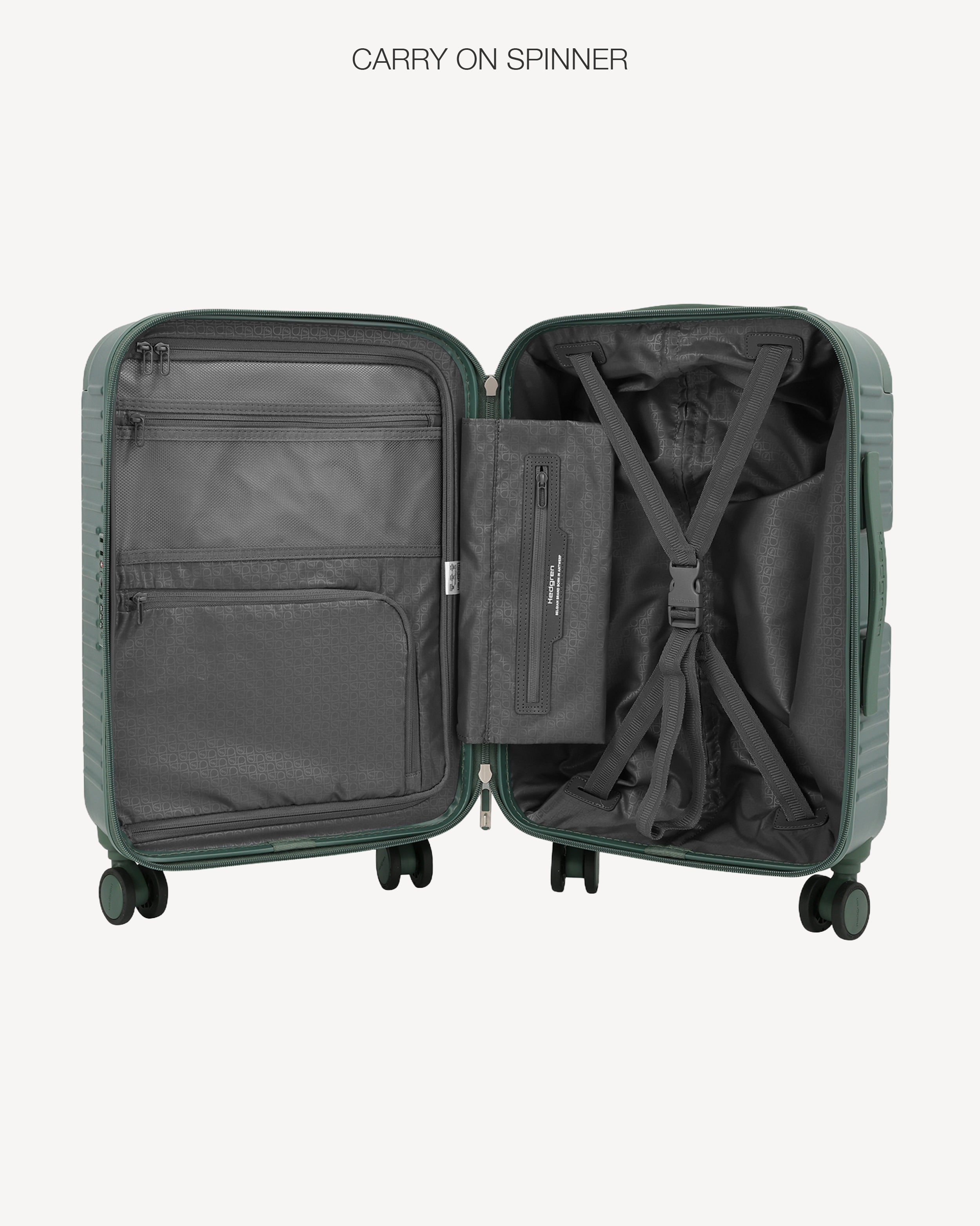 An open hard-shell carry-on spinner suitcase shown from the inside, revealing dark gray interior compartments, a zippered organizer pocket, and an X-straps system. The suitcase shell is a muted sage green.