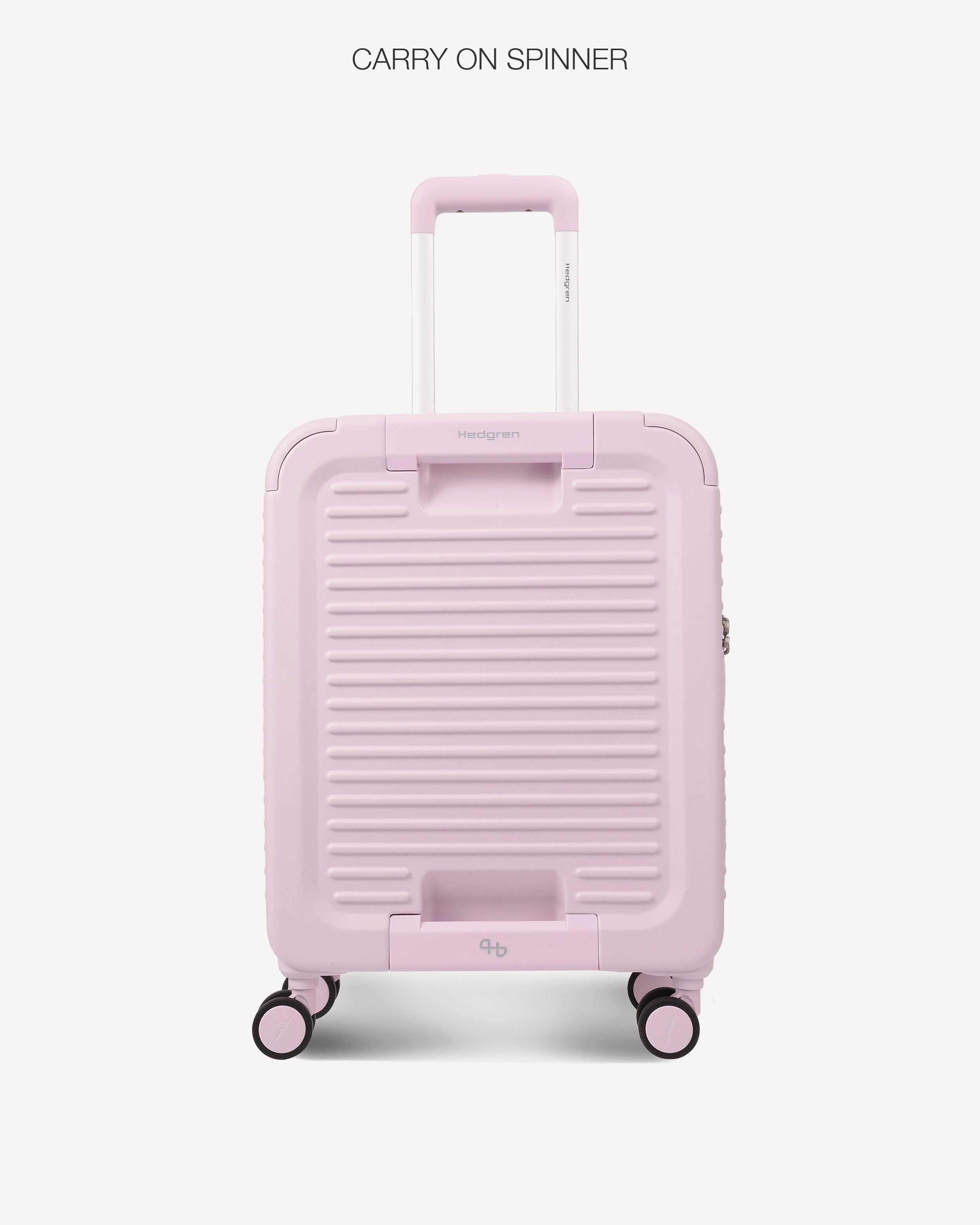A light pink hard-shell spinner suitcase with a ribbed front design, telescoping handle, and four wheels, shown against a light gray background with the text 'CARRY ON SPINNER' at the top.