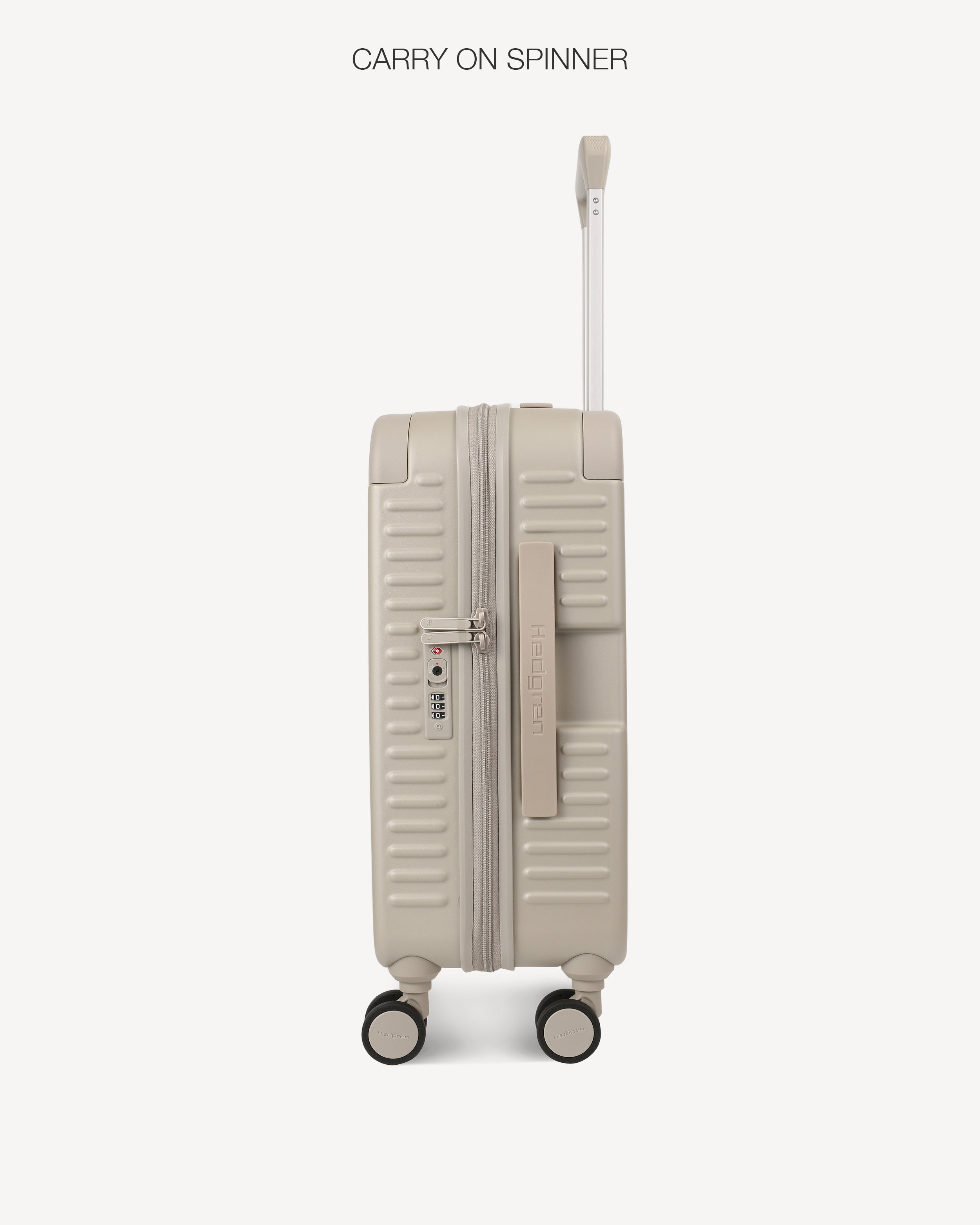 A hard-shell spinner suitcase in a light grey color, shown from the side with the telescoping handle extended. Its TSA lock and handle are shown. The text 'CARRY ON SPINNER' is printed at the top of the image.